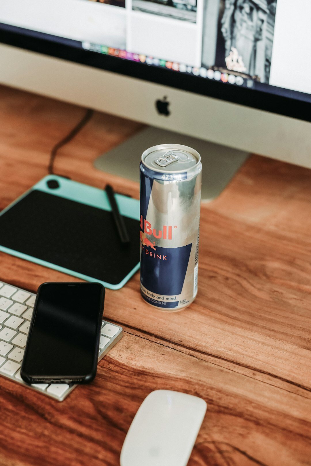 Laptop displaying a magazine style website next to a coffee cup on a desk